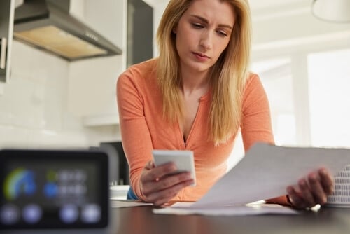Woman looking at energy bill with smart meter