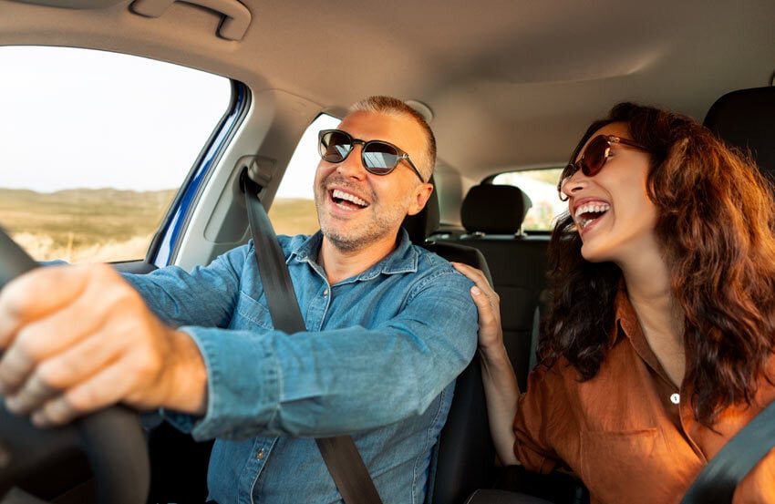 Man and woman laughing in a car