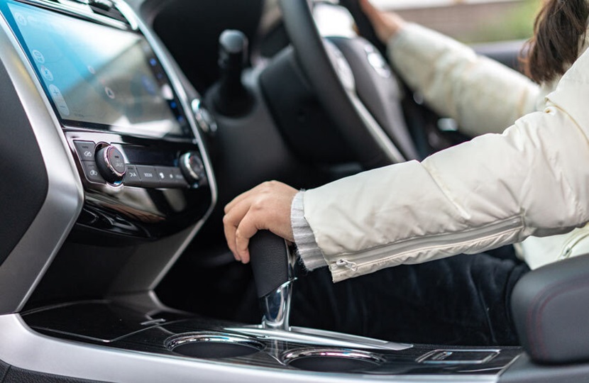 person driving a car with their hand on the gear stick