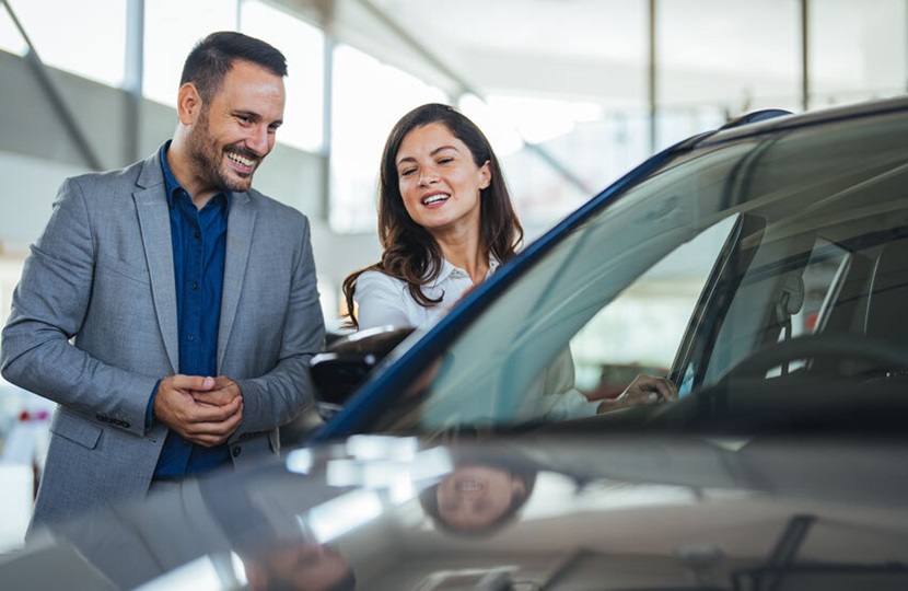 Two people looking at car