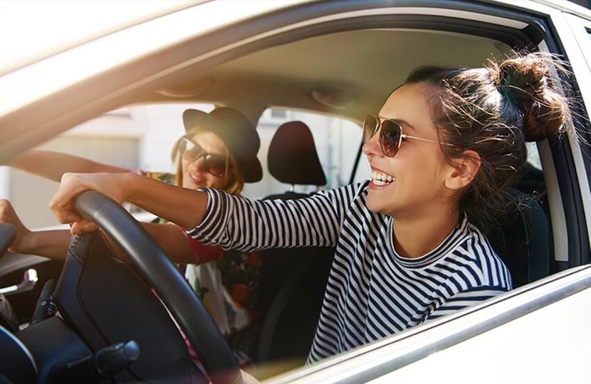 photo of two people in a car with the windows down