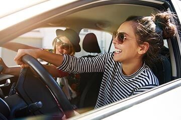 photo of two people in a car with the windows down