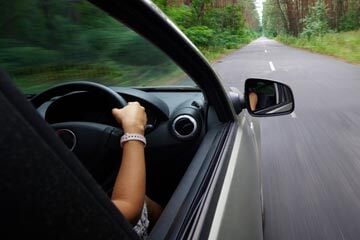 person driving a car with their hands on the steering wheel