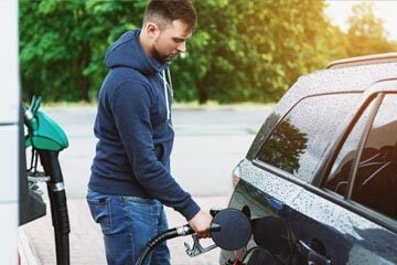 person putting fuel in their car