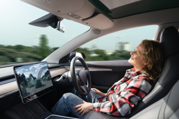 person sat in autonomous car