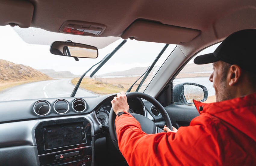 person driving a car on a road in bad weather