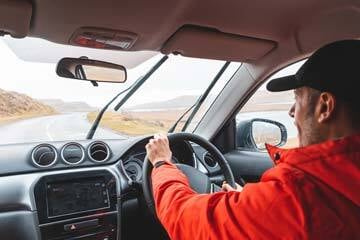 person driving a car on a road in bad weather