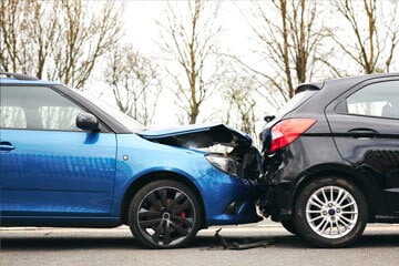 A blue car rear-ending a black one