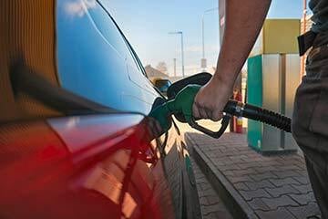 Person filling up their car with petrol at a fuel station