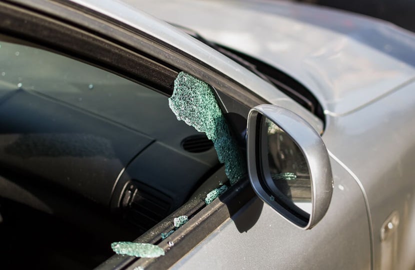 car window smashed with pieces of broken glass