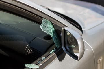 car window smashed with pieces of broken glass