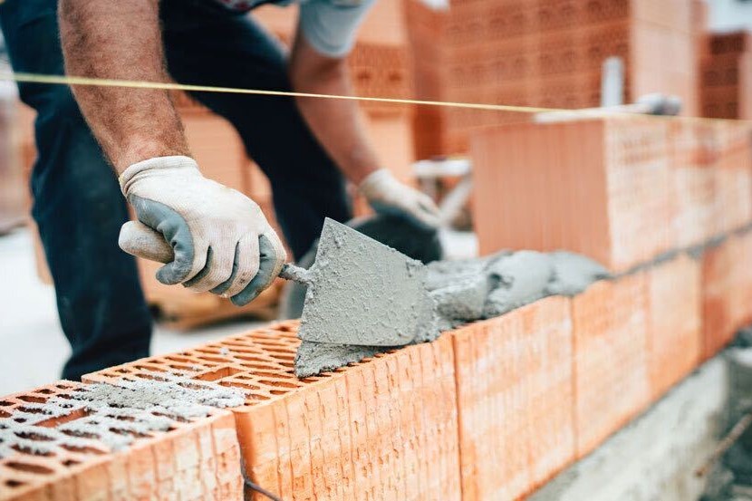 Person building a house with bricks