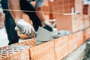 A person building a house with bricks