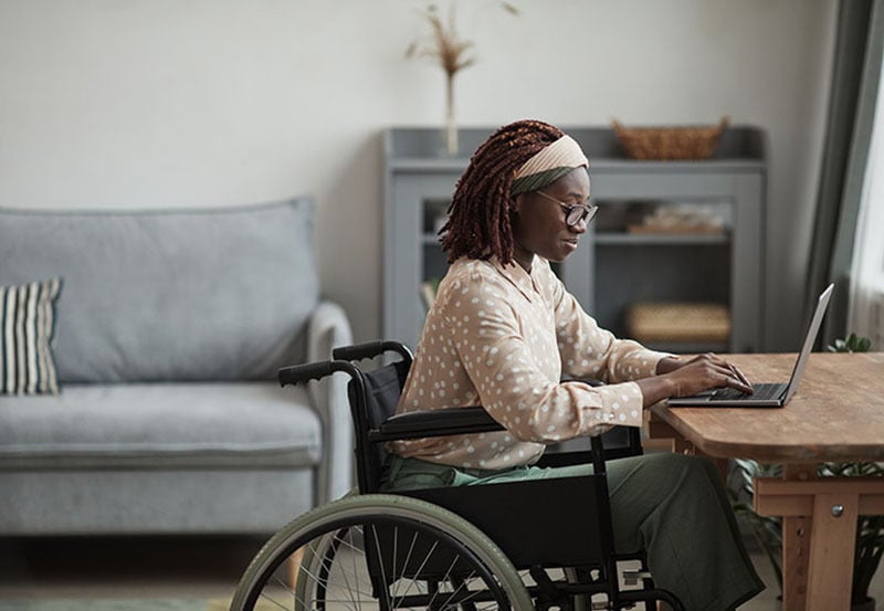 woman at her desk using her laptop