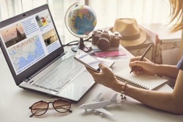 A woman booking a holiday on their laptop