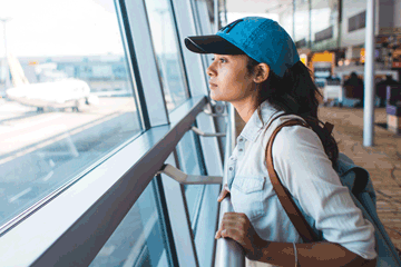 Woman looking out the window at an airport