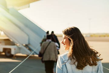 Woman walking towards an aeroplane.