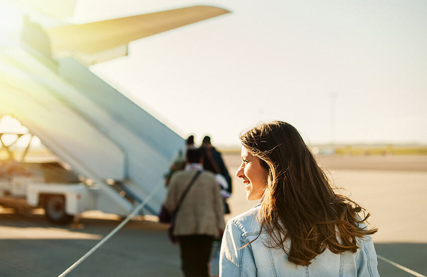 Woman walking towards an aeroplane.