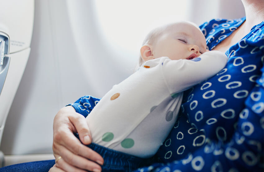 Infant asleep on parent  while on a plane